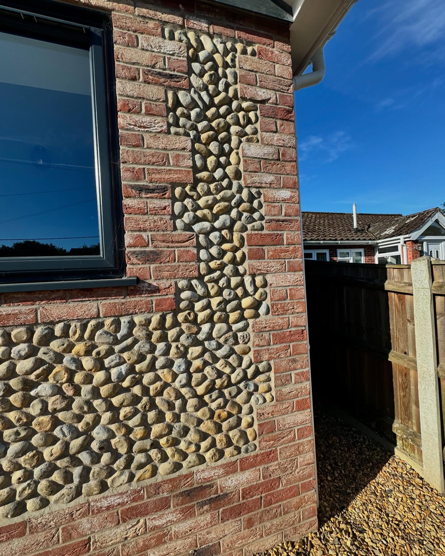 Detail of knapped flint panels set within red brick quoins and banding