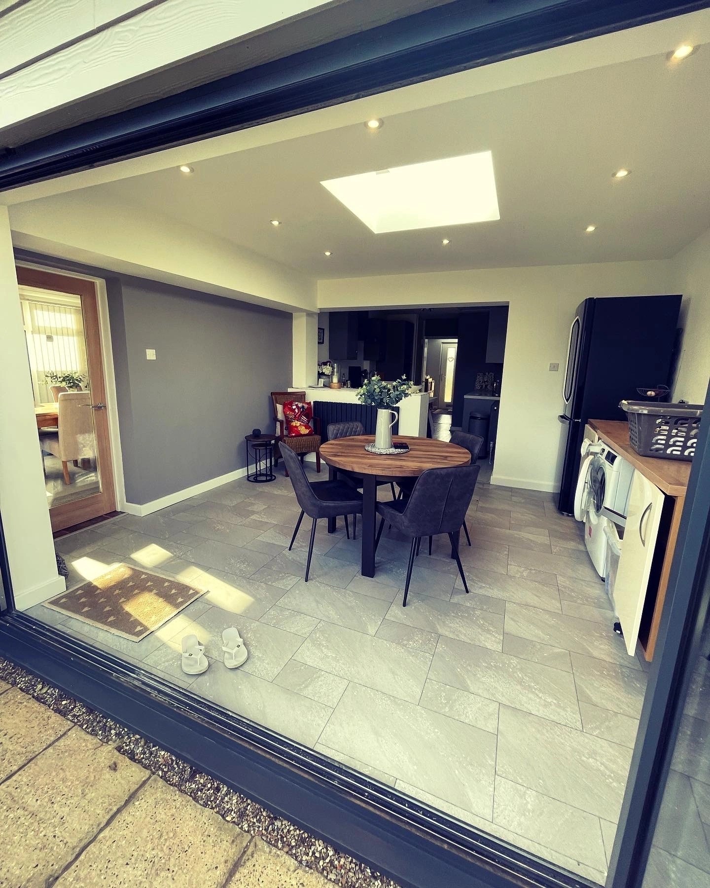 Grey clad single-storey extension in Old Hunstanton with anthracite bi-fold doors onto a paved terrace.