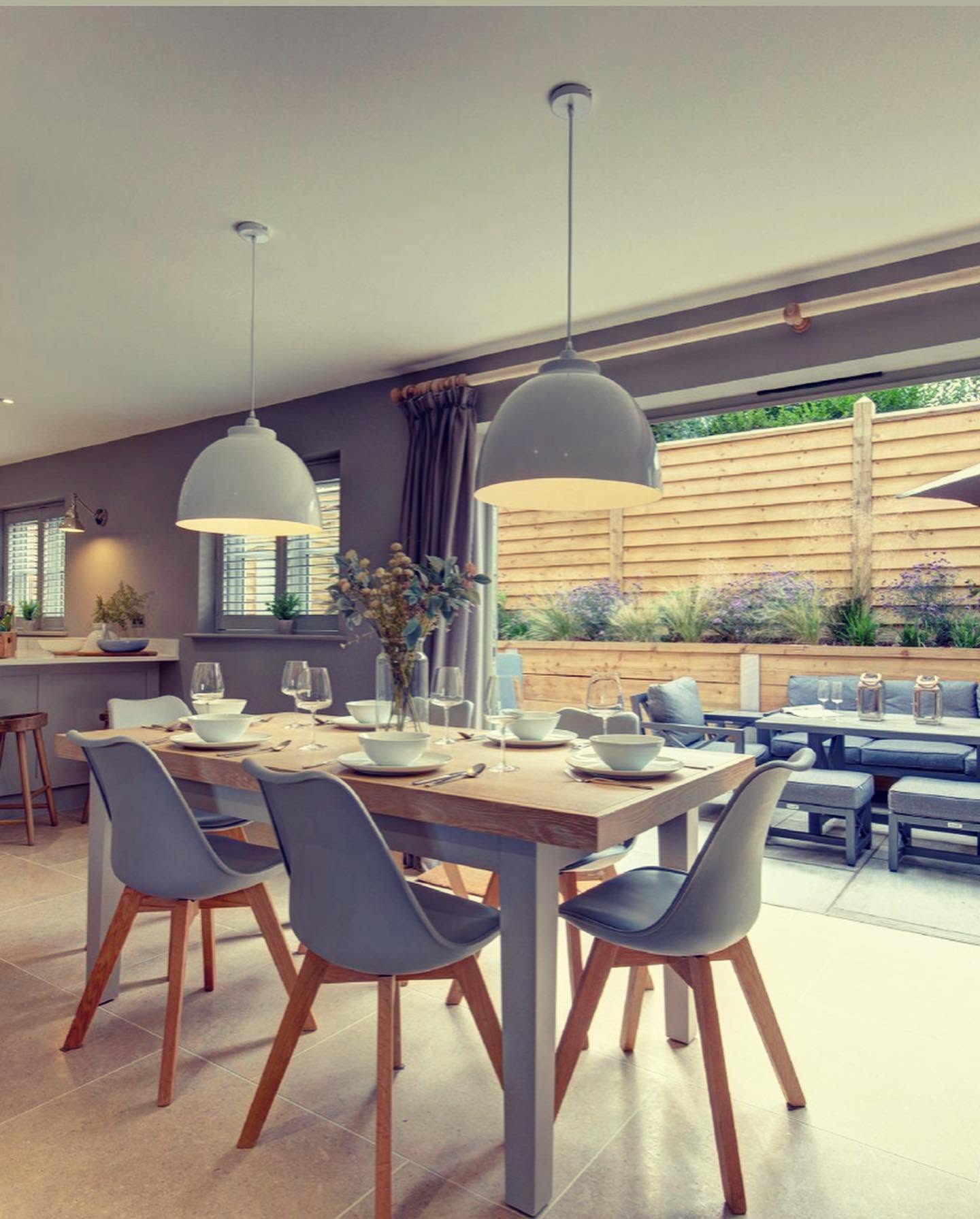Dining space opening to a terrace through full-height glazing