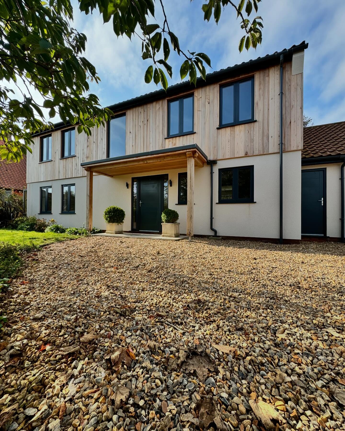 Cedar clad and rendered house with oak entrance canopy