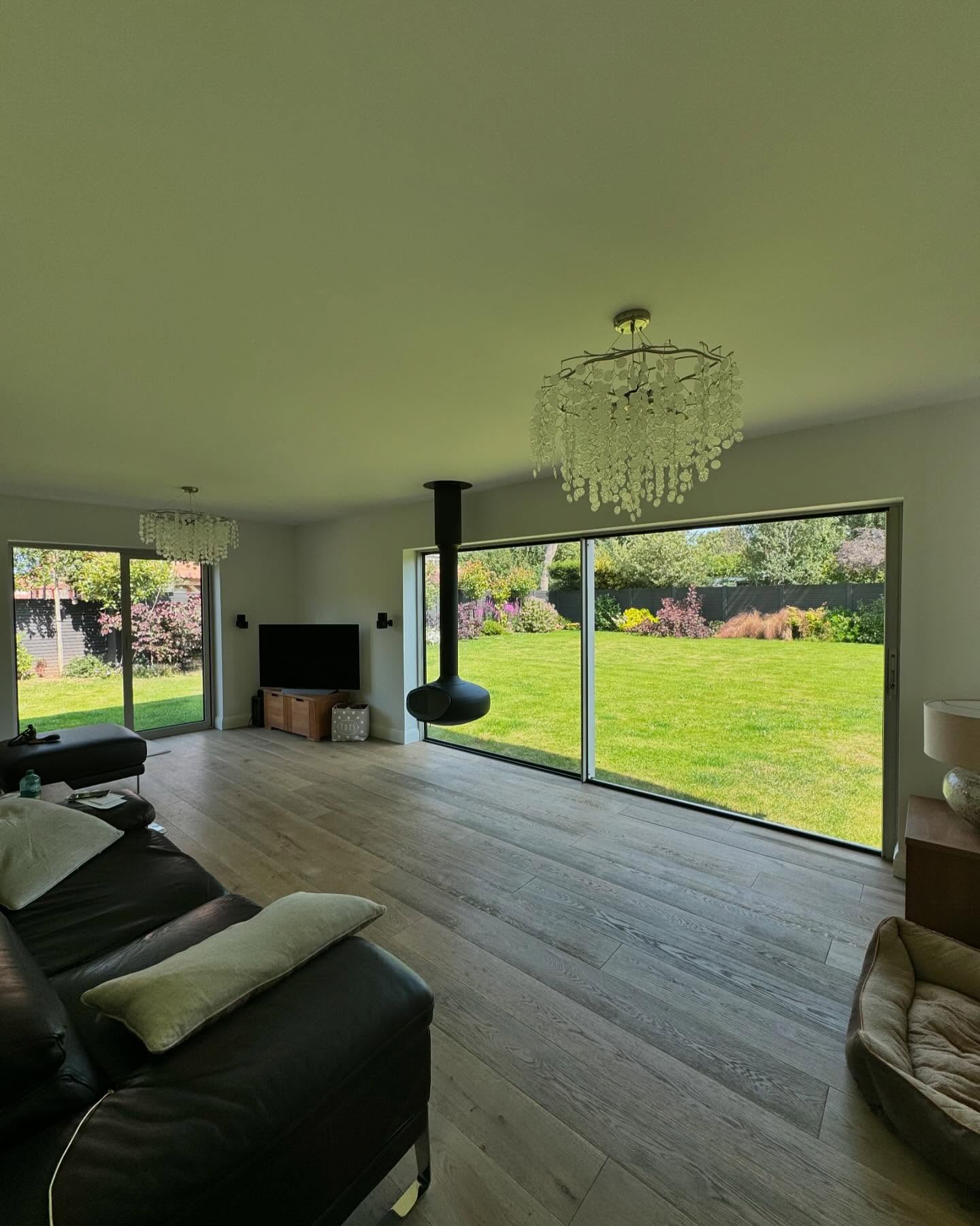 Living space with suspended wood burner and full-height sliding doors to garden