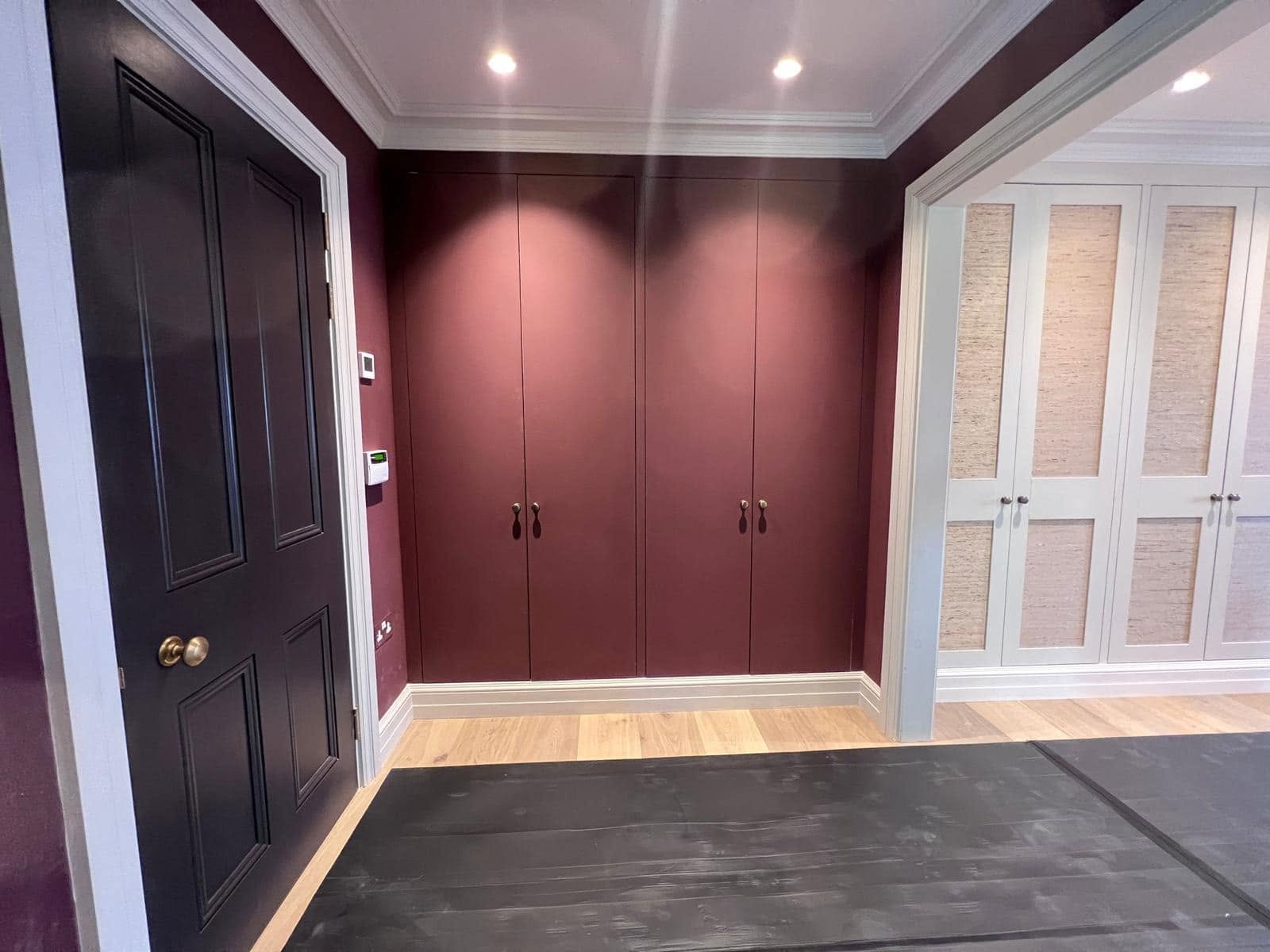 Bespoke painted wardrobes and panelled doors in a dressing room