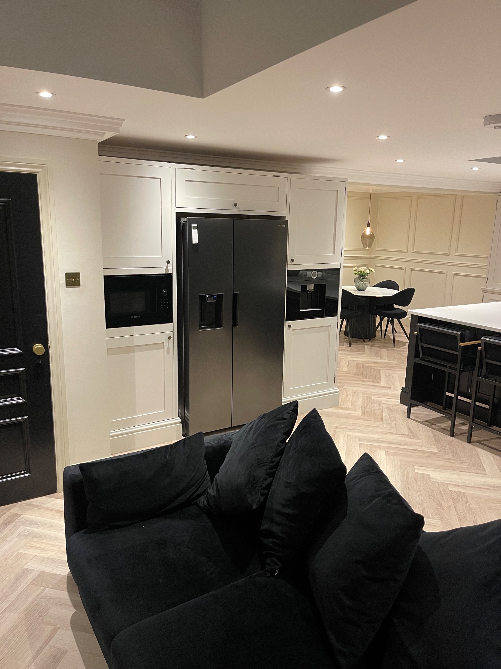 Brick garden room extension with black bifold doors open onto a porcelain terrace