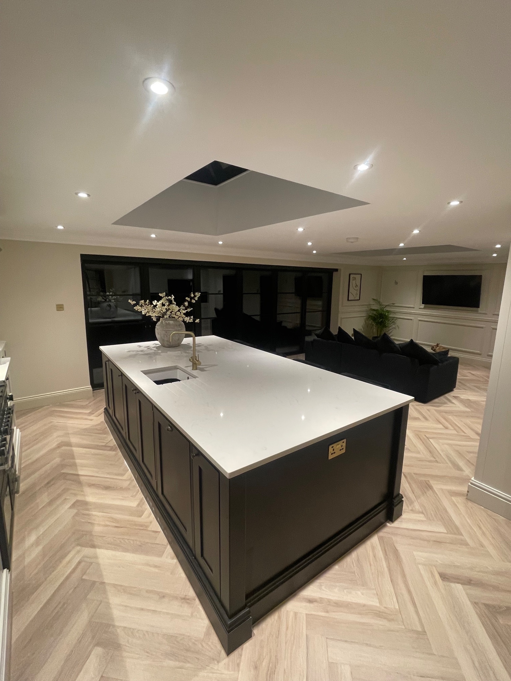 Brick garden room extension with black bifold doors open onto a porcelain terrace