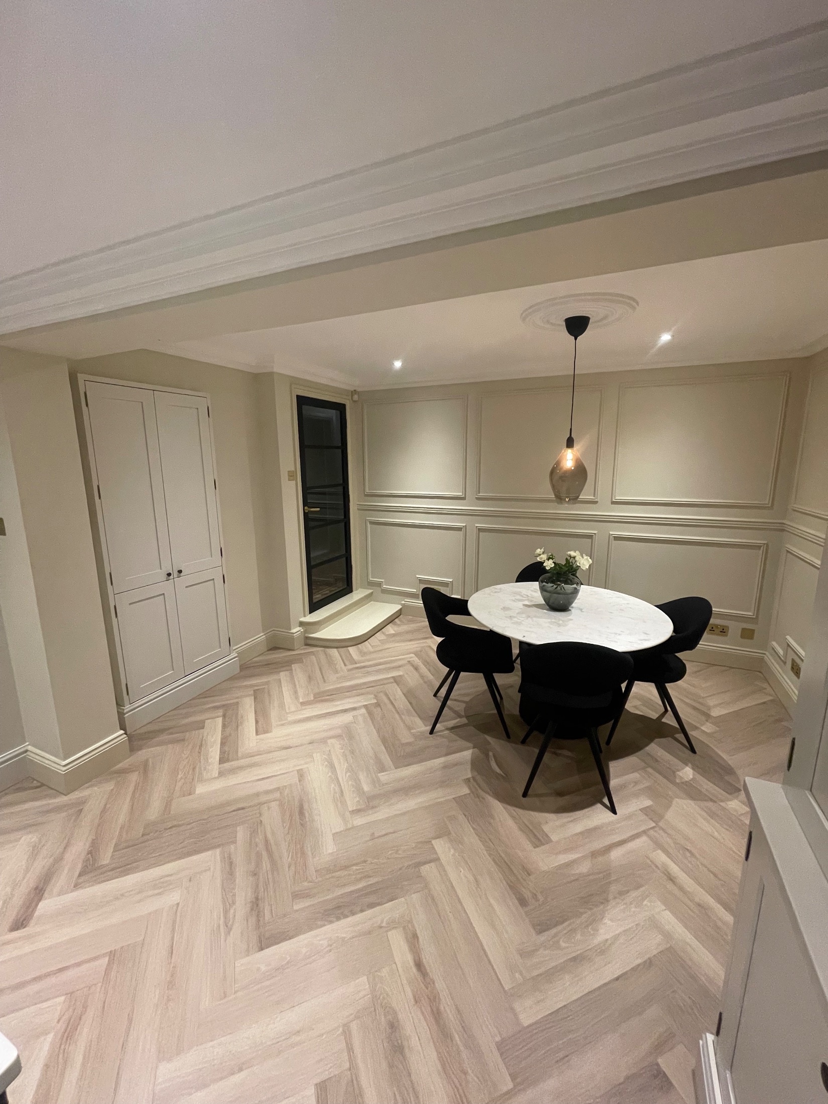 Brick garden room extension with black bifold doors open onto a porcelain terrace